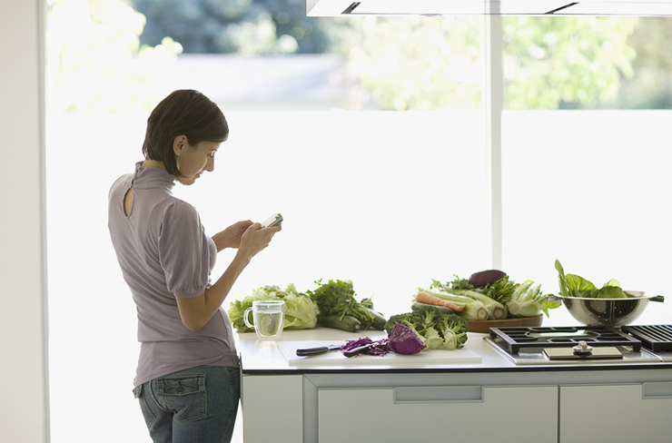 Woman Texting In Kitchen