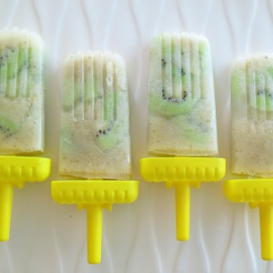 Creamy pear popsicles with chunks of kiwi and yellow sticks