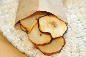 Dried pear rounds on white mat in brown paper